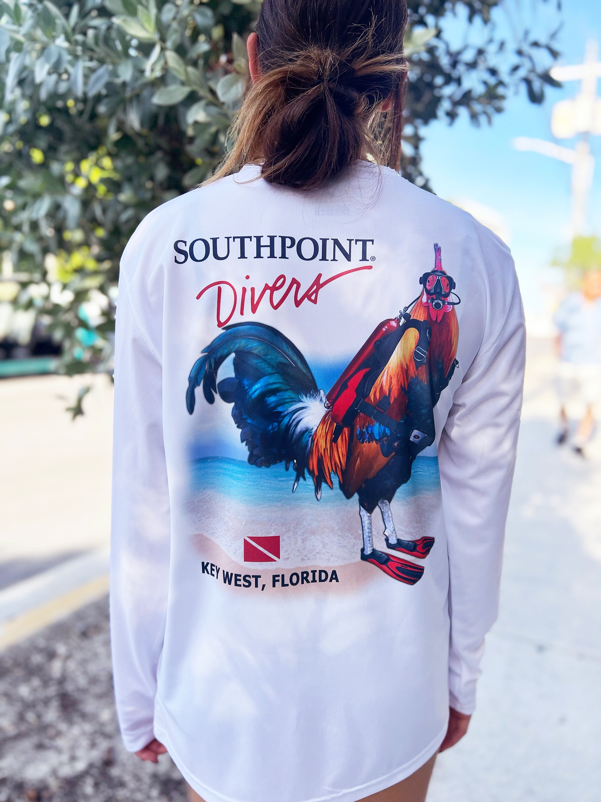 Person wearing white shirt with a rooster and 'Southpoint Divers' text.
